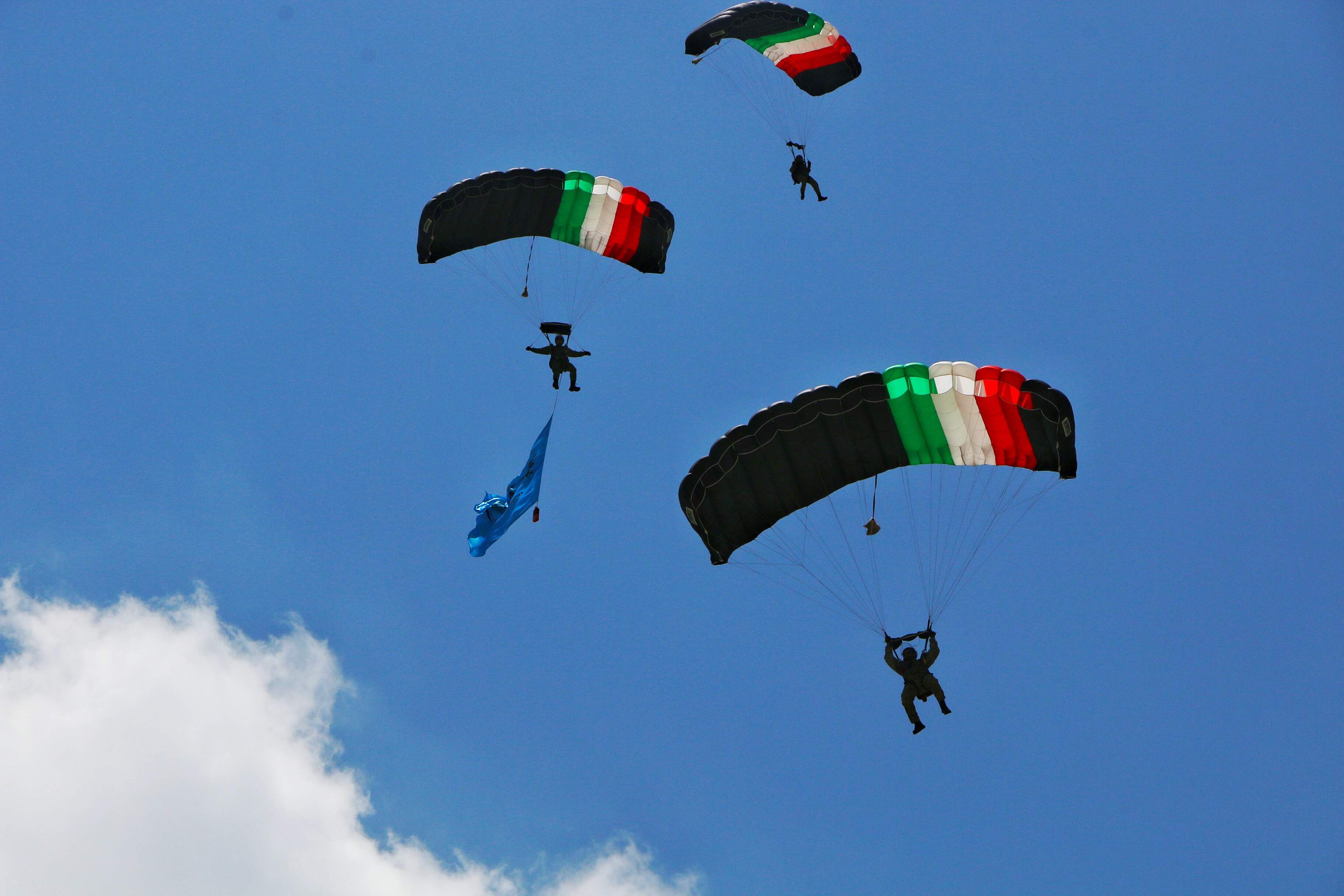 A group of Mexican Armed Forces paratroopers performs a descent during FAMEX 2025