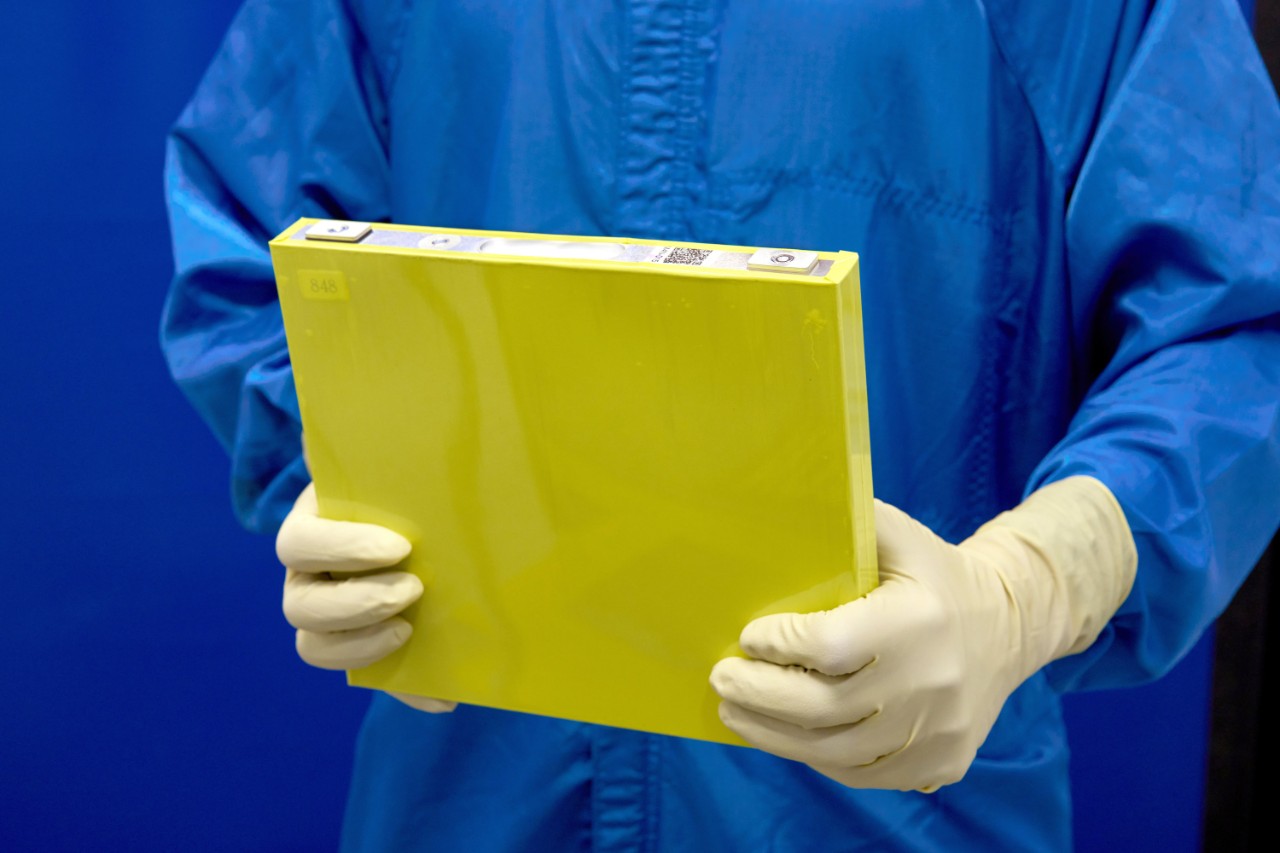 An employee holds a full-size prototype LMR battery cell at the General Motors Wallace Battery Cell Innovation Center